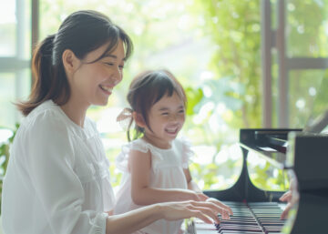 ピアノを弾く笑顔のお母さんと娘